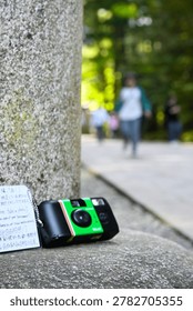 Compact Camera on Stone Surface at Shrine Pathway