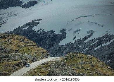 Compact Car on the Dramatic Norwegian Alpine Road with Glaciers near Geiranger, Vestland.