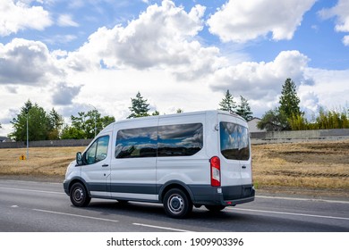 Compact Commercial Cargo Mini Van With Dark Glass Windows For Delivery And Small Business Services Running On The Highway Road With Cloud Sky