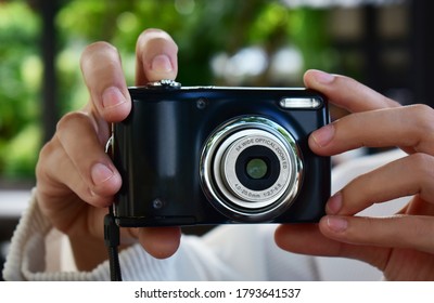 
Compact digital camera Black in hand with open lens