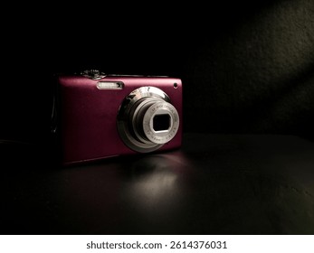 A compact digital camera on dark surface
