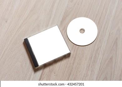 Compact Disc Template With Plastic Box With White Isolated Blank For Branding Design. CD Jewel Case Mock Up With Clean Free Space With Booklet For Print On Wooden Table. Perspective View