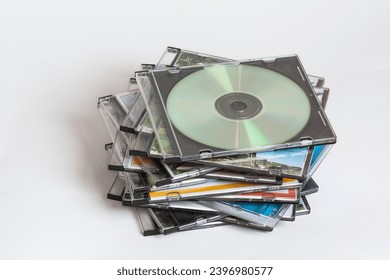 Compact discs in their boxes, stacked on a white background