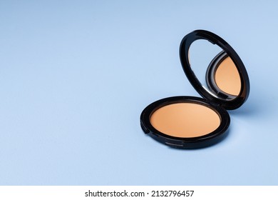 Compact face powder on blue background front view