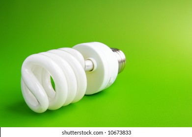 Compact Flourescent Light Bulb On Green (green Energy)