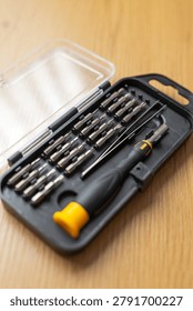 Compact precision screwdriver bit set with plastic case and yellow grip for electronics repair and diy toolkit background for product banner design.