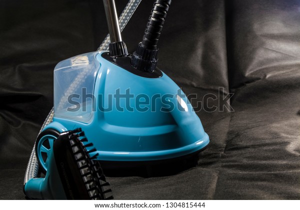 The compact, small vacuum cleaner for the\
house of blue color. Cleaning. Equipment. Modern technologies.\
Lovely appearance. Black\
background.