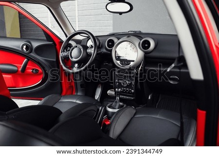 Compact, stylish and youthful crossover in bright red color. Modern black car interior.  Details interior. 