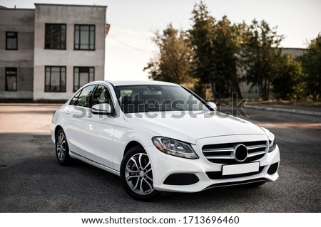 Compact white executive car, with beautiful wheels, large chrome grille.