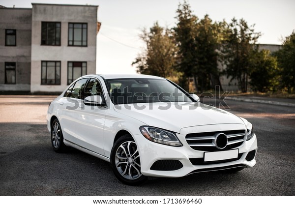 Compact white executive car, with beautiful\
wheels, large chrome\
grille.