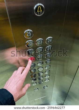 In a compact yet highly efficient elevator designed specifically for swift transport, an eager individual eagerly presses a bright red button, urging the desired movement to begin and take place