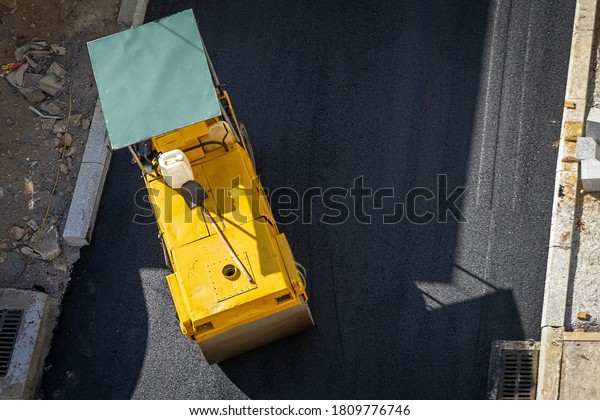 \
Compacting asphalt with Steel Wheel Roller.  Scheduled repair of\
asphalt pavement in the city street. View fom\
above.