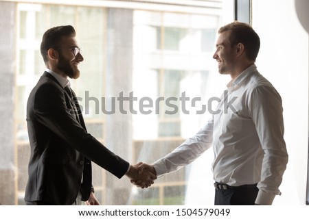 Company boss welcoming corporate client or multi-ethnic arabian european colleagues met at office hallway greet each other shaking hands express respect and nice to meet you friendly relations concept