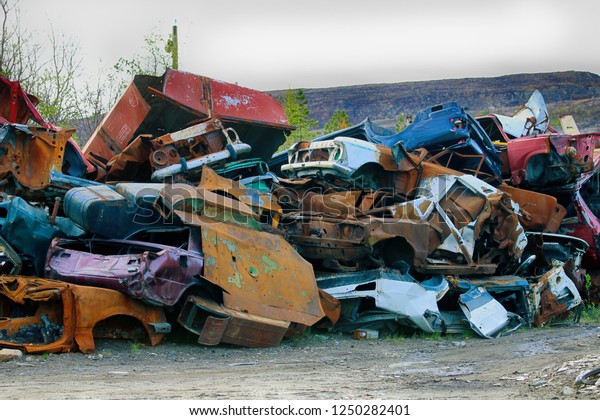 The company for the disposal of cars,\
junk yard, scrappage of motor vehicles. The bodies of cars stacked\
in piles on the background of bare man-made\
hills