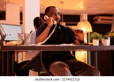 Company Employee Answering Landline Phone Call To Talk To Manager About Paperwork Report On Computer. Chatting On Office Telephone Line, Having Remote Conversation About Business Documents.