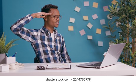 Company Employee Doing Military Salute With Hand Over Temple, Showing Respect For Business And Boss While He Works On Laptop. Worker Advertising Army Soldier Gesture, Saluting Manager.