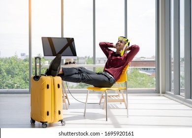 Company Employees Sit Thinking Of Traveling And Relaxing During The Annual Holidays.Young Asian Businessman Preparing For Vacation In The Office.