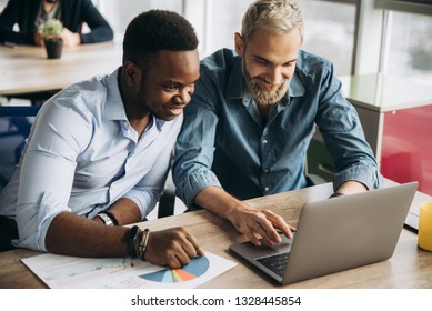 Company employees work at a laptop in their office developing new successful ideas for their company - Shutterstock ID 1328445854
