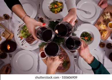 Company Of Friends Having Fun At Dinner In A Restaurant. On The Table A Variety Of Dishes From The Chef. They Clicked Their Glasses Of Wine. Conceptual Photography View From Above