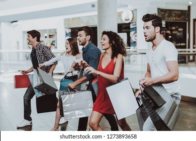 Company of Friends Shopping in Mall with Packages. Shopping Concept. Girl in Red Dress. Woman in White Shirt. Black Friday Concept. Exited Young People. Modern Market. Packs in Hands. - Shutterstock ID 1273893658