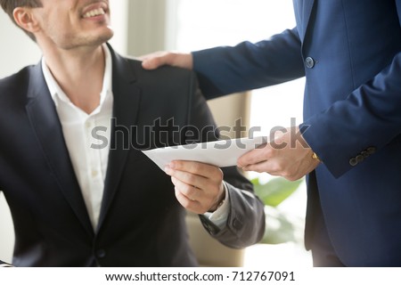 Company leader giving money bonus in paper envelope to happy smiling office worker, congratulating employee with increasing of salary or promotion, thanking for successes in work. Close up concept 