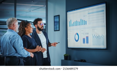 Company Operations Manager Holds Meeting Presentation. Diverse Team Uses TV Screen with Growth Analysis, Charts, Statistics and Data. People Work in Business Office. - Shutterstock ID 2136489279