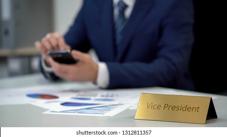 Company vice president using mobile app for working on documents, calculating