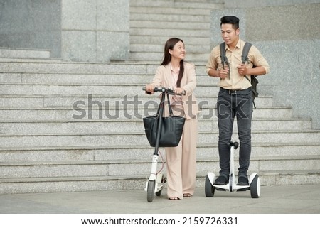 IT company workers talking when riding on e-scooters home after work