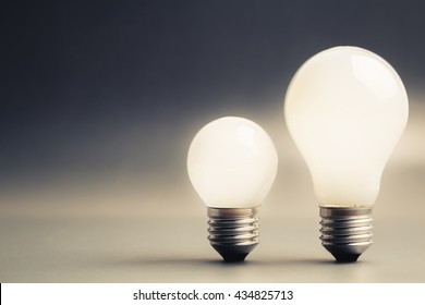 Comparative big and small light bulb, small and medium sized business, coaching, training, or other comparison concept