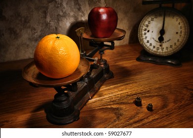 Comparing apple and orange on an antique scale as a metaphor for the age old timeless saying