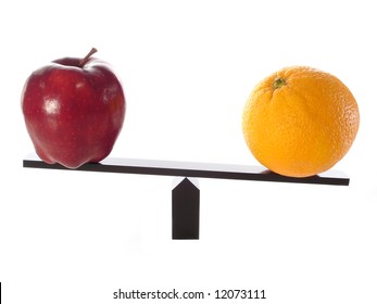 Comparing apples to heavy oranges on a balance beam isolated on white.