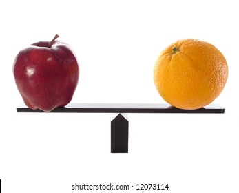 Comparing Apples to Oranges on a Balance Beam isolated on white.