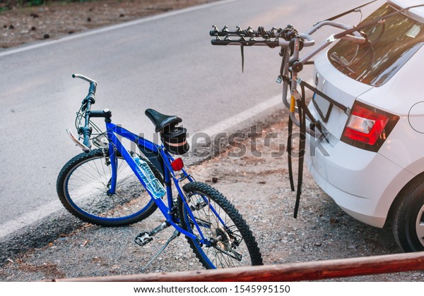 Comparison between a bike and a\
car eco drive and petrol drive. Parked bicycle and car on an empty\
road.