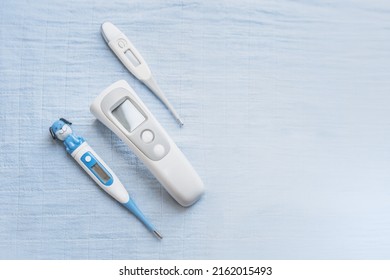 Comparison of infrared and electronic thermometer baby thermometer for measuring human body temperature on blue medical background. Types of thermometers. copy space