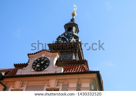The comparisson of two clocks. The regular with arabic numbers and the jewis one. They are on one tower of the church. 