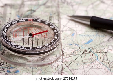 A Compass Alongside A Road On A Map With A Pencil