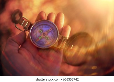 Compass with an arrow in the hand indicating the path