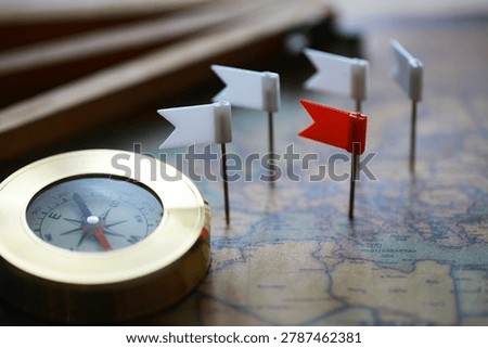 Compass and Flag Pins on Map Representing Navigation, Direction, and Strategic Planning