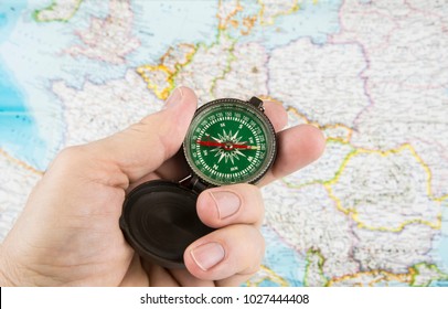 Compass in the hand with map in the background