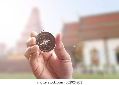 compass in hand on thai temple blur background with lighting flare - Shutterstock ID 332924201