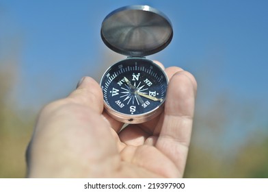 Compass in hand. Open the magnetic compass holds the left hand men. - Shutterstock ID 219397900