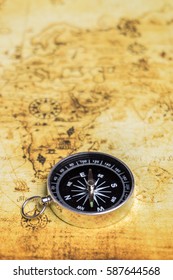 A compass isolated over vintage world map - Shutterstock ID 587644568