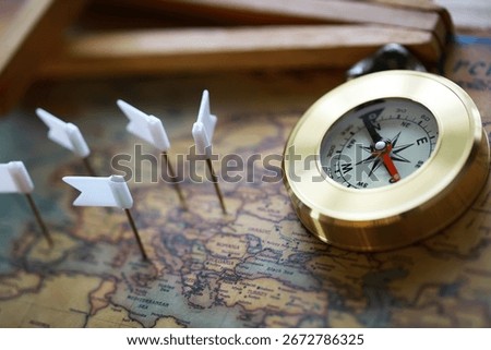 Compass and Map with White Flags Marking Travel Destinations Highlighting Adventure and Travel Planning