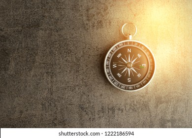 Kompass auf dunkelschwarz strukturierter Tafel mit künstlich goldenem Flair mit Kopienraum als Fahrtrichtung, Reise- oder Abenteuerkonzept.