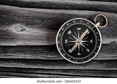 compass on dark wooden background concept direction motion top view