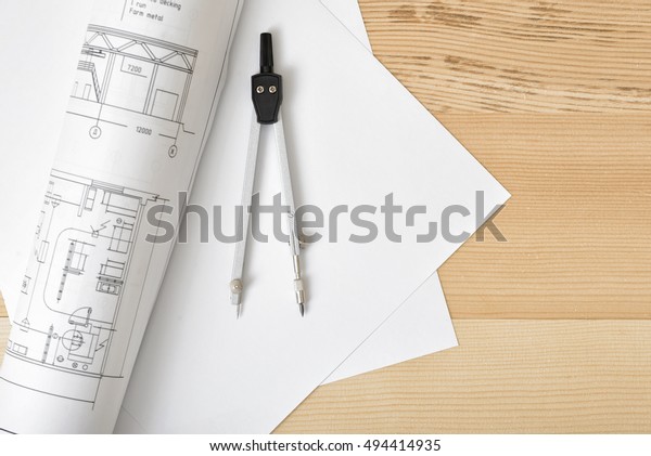 Compass on white paper
in top view with copy space. Workplace of architect, constructor,
designer. Start a new project. Construction and architecture. Tools
for drawing.
