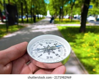 A Compass In Person's Hand In Park. Orient Yourself In Current Situation (urban Conditions). Follow Innner Compass, Intuition Concept, Public Sentiments