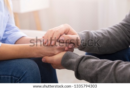 Compassion and concern concept. Psychiatrist supporting his patient hands during therapy
