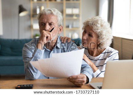 Compassionate elderly woman supporting upset stressed mature husband, received bad news banking letter. Unhappy depressed family married couple having financial trouble, got house eviction notice.