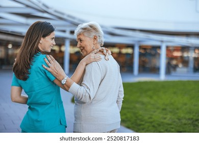 A compassionate nurse provides support and care for an elderly woman in an outdoor hospital environment. The scene conveys trust, kindness, and professionalism in healthcare services. - Powered by Shutterstock